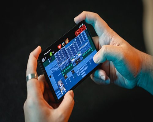 Smartphone displaying a fictional mobile game during a StudioOrbitCrown Australian gaming technology exhibition